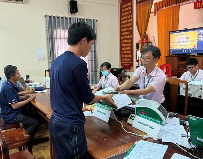 Cán bộ NHCSXH huyện Phú Riềng giải ngân gói vay ưu đãi dành cho người chấp hành xong án phạt tù tại trụ sở Ngân hàng huyện.